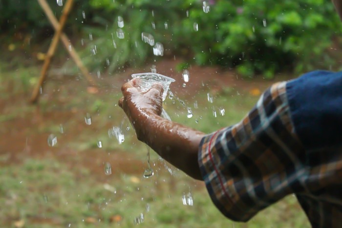 hands with splashes of falling rain