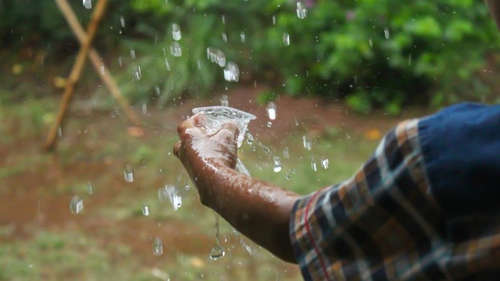 hands with splashes of falling rain