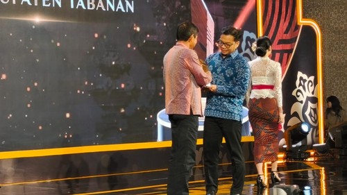 Pemimpin Redaksi detikcom, Ardhi Suryadhi menyerahkan penghargaan kepada Asisten I Pemerintahan dan Kesra Tabanan, Anak Agung Ngurah Satria Tenaya, yang mewakili Bupati Tabanan, I Komang Gede Sanjaya di detikBali-Nusra Awards 2026.