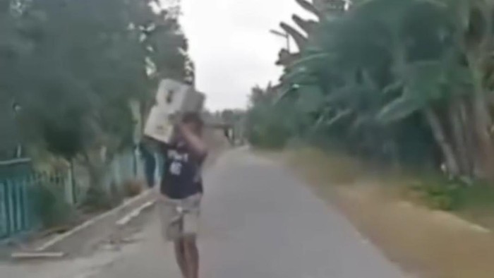 Tangkapan layar momen pria diduga pencuri AC membawa kembali barang curiannya ke rumah korban