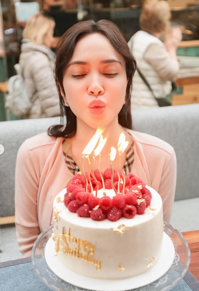 Sebelumnya Shandy juga terlihat merayakan ulang tahun dengan tampil sederhana. Sambil meniup kue ulang tahun, Shandy terlihat mengenakan cardigan dengan list kotak-kotak khas merek mewah Burberry. Riasannya terlihat natural dengan lipstik nude. Foto: Instagram/@shandyaulia