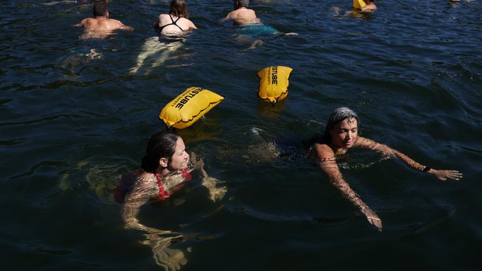 A person jumps into the River Seine at the Grenelle public bathing site, which is open to swimmers for the second year in the capital's historic waterway, with the Eiffel Tower in the background, in Paris, France, July 4, 2026. REUTERS/Tom Nicholson     TPX IMAGES OF THE DAY