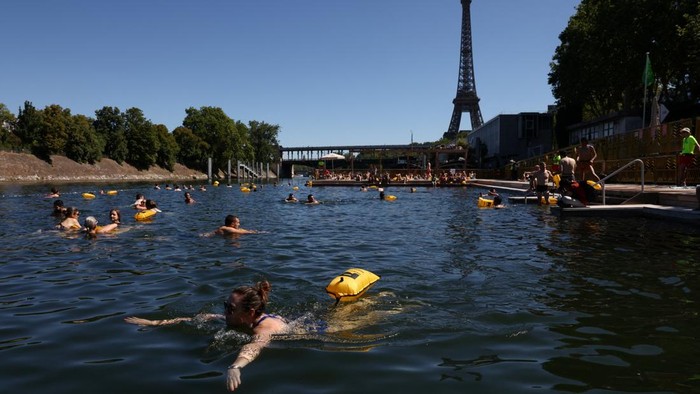 A person jumps into the River Seine at the Grenelle public bathing site, which is open to swimmers for the second year in the capital's historic waterway, with the Eiffel Tower in the background, in Paris, France, July 4, 2026. REUTERS/Tom Nicholson     TPX IMAGES OF THE DAY