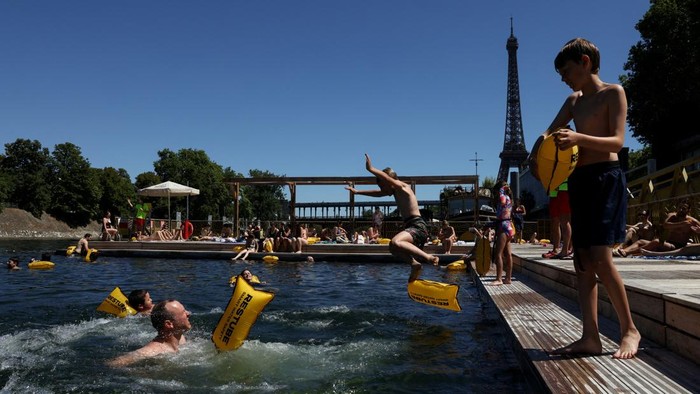 A person jumps into the River Seine at the Grenelle public bathing site, which is open to swimmers for the second year in the capital's historic waterway, with the Eiffel Tower in the background, in Paris, France, July 4, 2026. REUTERS/Tom Nicholson     TPX IMAGES OF THE DAY