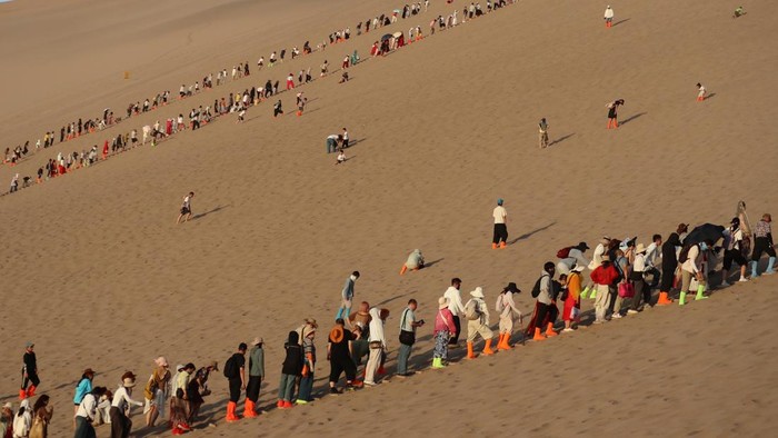 Wisatawan lokal mengunjungi kawasan wisata Gunung Mingsha di Gurun Gobi, Kota Dunhuang, Provinsi Gansu, China, Jumat (3/7/2026). Gunung Pasir Bernyanyi (Mingsha) terkenal karena bukit pasir tersebut mengeluarkan suara ketika angin bertiup atau saat orang meluncur di atasnya. ANTARA FOTO/Desca Lidya Natalia/kye