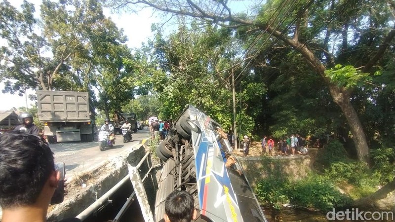 Bus terguling ke sungai usai bertabrakan dengan truk di Jembatan Paron, Nganjuk. Seluruh korban dievakuasi ke rumah sakit.