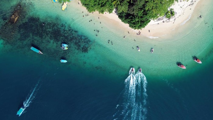 Foto udara wisatawan beraktivitas di kawasan pantai Pulau Cingkuak, Painan, Kabupaten Pesisir Selatan, Sumatera Barat, Sabtu (4/7/2026). Pemkab Pesisir Selatan berupaya melakukan pembenahan destinasi wisata pulau-pulau kecil di kabupaten itu, salah satunya dengan menentukan tarif retribusi resmi antar-jemput ke Pulau Cingkuak sebesar Rp21 ribu per orang termasuk asuransi. ANTARA FOTO/Fitra Yogi/kye