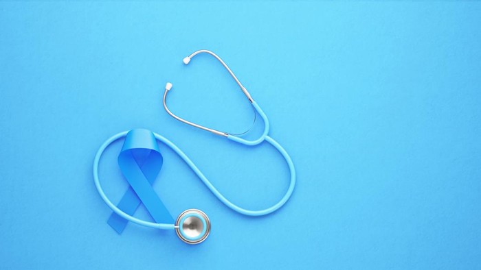 Prostate cancer awareness ribbon and stethoscope on blue background. Horizontal composition.