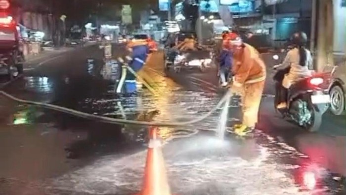 Petugas membersihkan tumpahan oli di Jalan Agus Salim, Kecamatan Batu, Kota Batu
