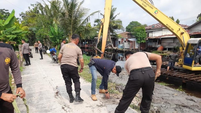 Kepolisian bersama warga membersihkan sekitar lokasi jembatan di Kecamatan Dumai Selatan, Kota Dumai menjelang diresmikan Kapolri Jenderal Listyo Sigit Prabowo (Polda Riau)