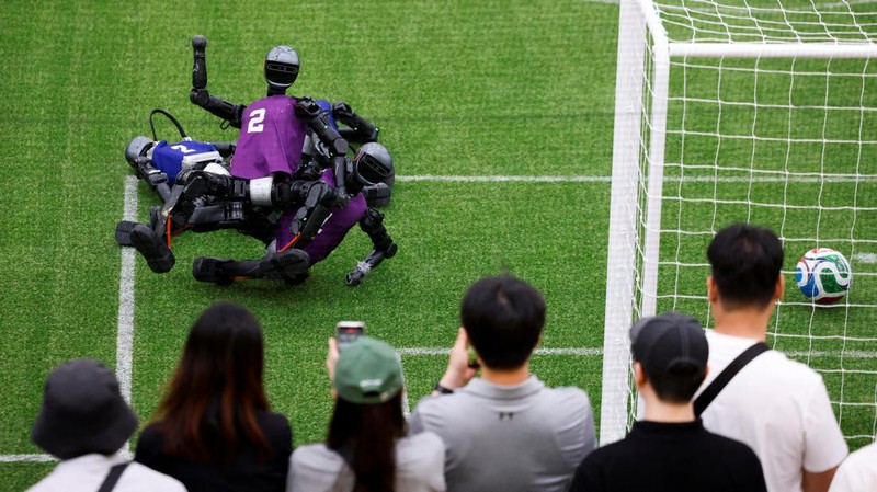 Kemajuan teknologi robotika kembali menjadi sorotan dalam ajang RoboCup 2026 yang digelar di Incheon, Korea Selatan, Minggu (5/7/2026). Kompetisi robot internasional tersebut menampilkan aksi robot humanoid yang bertanding layaknya atlet sungguhan. Pada partai final Divisi Besar, Tim Hephaestus dari Universitas Tsinghua berhadapan dengan Tim Universitas Pertanian Pegunungan dan Laut Tiongkok dalam pertandingan yang menyita perhatian para pengunjung. REUTERS/Kim Soo-hyeon