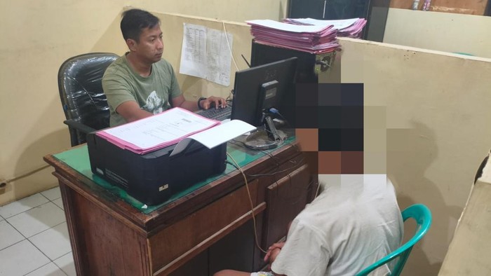 Salah satu pencuri kabel tower telekomunikasi di Candi Sidoarjo saat menjalani pemeriksaan di kantor polisi.