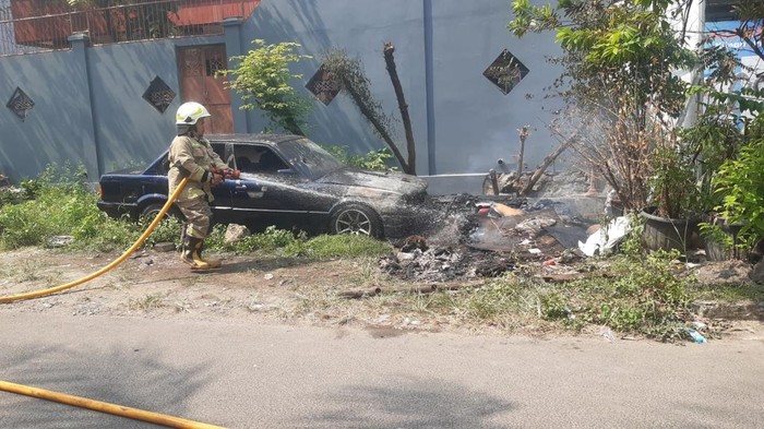 Satu unit mobil jenis sedan terbakar di Jakbar. Kebakaran diduga dipicu pembakaran sampah yang kemudian ditinggal hingga apinya menjalar ke mobil. (Dok. Damkar Jakbar)