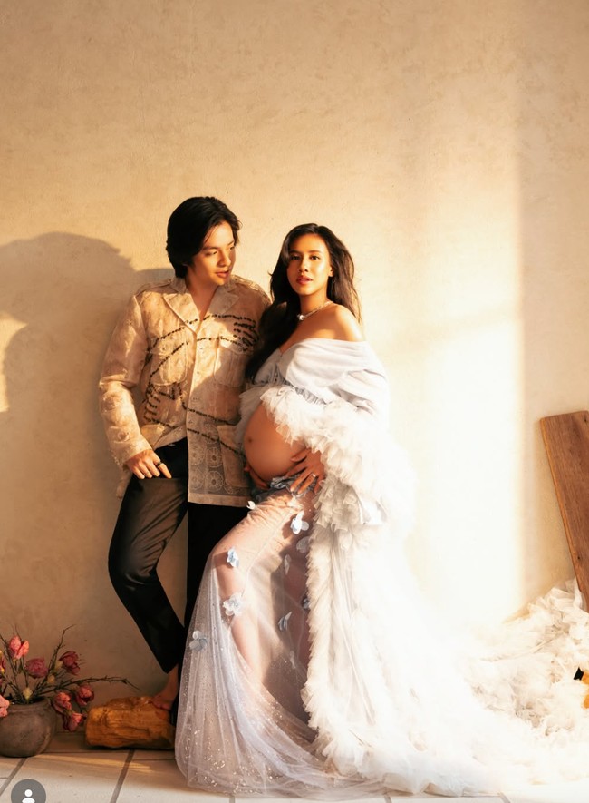 Shenina memilih busana yang memperlihatkan bare baby bump dengan elegan. Atasan off shoulder dipadukan kain transparan membuat perut besarnya menjadi pusat perhatian tanpa terlihat berlebihan. Foto: Instagram/@sheninacinnamon