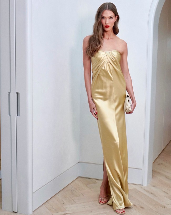 Karlie Kloss tampil ultra-glam dalam balutan tube dress emas metalik dari koleksi Tove Studio. Karlie memadukan gaunnya dengan strappy heels warna senada. Foto: Instagram/Jacob Rozenberg