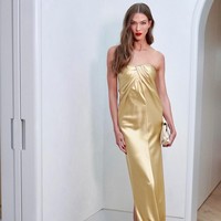 Karlie Kloss tampil ultra-glam dalam balutan tube dress emas metalik dari koleksi Tove Studio. Karlie memadukan gaunnya dengan strappy heels warna senada. Foto: Instagram/Jacob Rozenberg