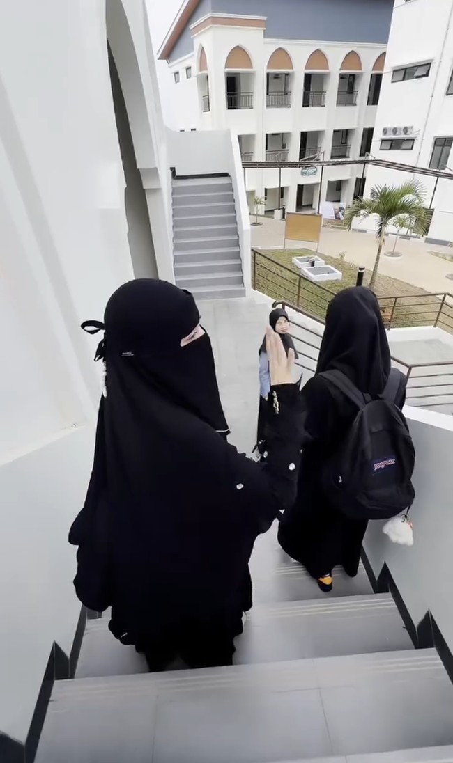 Celine Evangelista memakai gamis panjang berwarna hitam dengan potongan loose saat mengantar anak ke pesantren. Ia juga terlihat memakai cadar dan niqab hitam. Foto: Dok. Instagram @celine_evangelista.