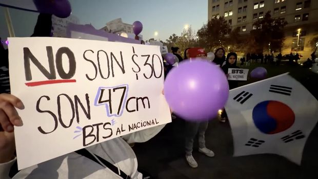 BTS berkumpul di depan Istana Kepresidenan Palacio de la Moneda, Cile, pada Jumat (3/7), untuk memprotes pembatalan konser grup K-pop tersebut yang sedianya digelar di Stadion Nasional, Santiago, pada Oktober mendatang. (Tangkapan Layar Video Reuters/)