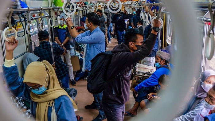 Penumpang menaiki KRL Commuter Line di jalur hijau 