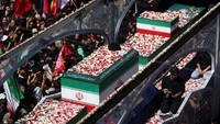 Peti jenazah Khamenei yang diselimuti bendera Iran diarak menggunakan kendaraan khusus bersama peti jenazah sejumlah anggota keluarganya yang juga tewas dalam serangan tersebut. Prosesi berlangsung dari Lapangan Enghelab menuju Bandara Mehrabad. REUTERS/Murad Sezer