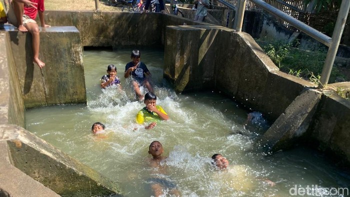 Keseruan anak-anak bermain air di Desa Kliwed, Kecamatan Kertasemaya, Kabupaten Indramayu.