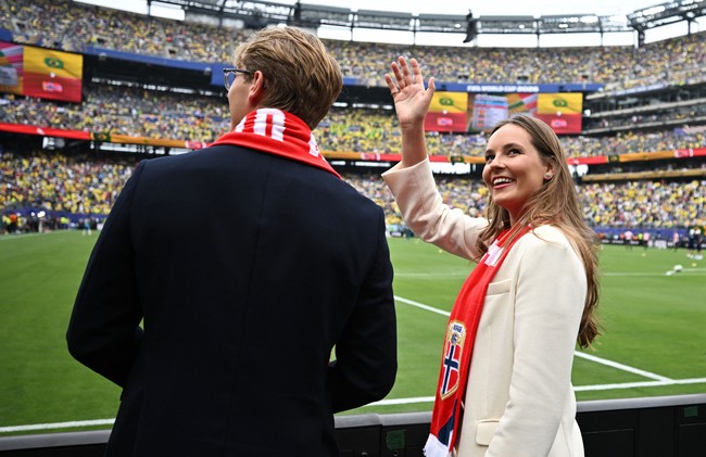 Sang putri ditemani adiknya, Pangeran Sverre Magnus, saat menonton langsung di Stadion New Jersey, New York, AS. Keduanya kompak memakai scarf bertuliskan nama negara dan bendera mereka sebagai bentuk dukungan. Foto: REUTERS/Dylan Martinez