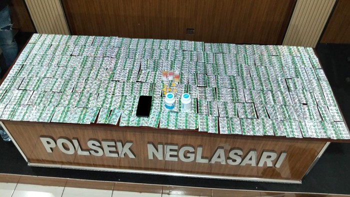 Polisi menangkap seorang pria berinisial UA (23) di Desa Buaran Mangga, Kecamatan Pakuhaji, Kabupaten Tangerang, Banten. Barang bukti ribuan pil disita polisi.