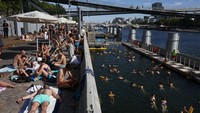Berenang di Sungai Seine sempat dilarang sejak 1923 akibat tingginya tingkat pencemaran. Kini, sungai tersebut kembali menjadi ruang rekreasi publik setelah kualitas air dinilai memenuhi standar kesehatan pada sebagian besar waktu. REUTERS/Tom Nicholson 