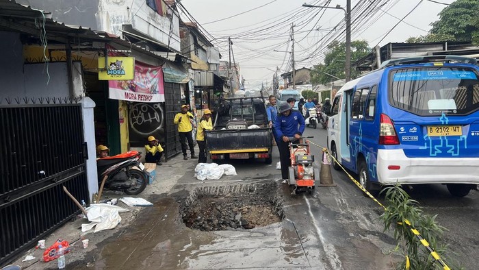 Satu lajur jalan di Jalan Assirot, Kebon Jeruk, Jakarta Barat (Jakbar) amblas dan viral di medsos. Petugas kini memperbaiki jalan amblas tersebut. (Adhfar/detikcom)