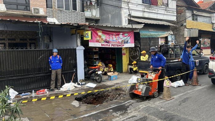 Satu lajur jalan di Jalan Assirot, Kebon Jeruk, Jakbar, amblas dan viral di medsos. Petugas kini memperbaiki jalan amblas tersebut. (Adhfar/detikcom)