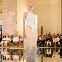 Seperti dijelaskan di situs Schiaparelli, look nomor 30 ini hadir dengan bustier ‘porselen’ yang terbuat dari silikon yang dihiasi detail lacing pada bagian belakang. Bagian rok bertabur mutiara yang dibordir, lalu dilukis dengan teknik sfumato yang menciptakan efek gradasi. (Foto: Dok. Schiaparelli)