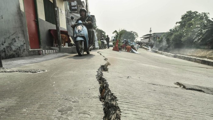 Foto udara suasana Jalan Cinta yang ambles di Pulo Gadung, Jakarta, Selasa (7/7/2026). Menurut warga kondisi tersebut telah berlangsung selama lima bulan dan menyebabkan jalan hanya dapat dilalui kendaraan roda dua serta Suku Dinas Sumber Daya Air (Sudin SDA) memasang dolken di bantaran kali sebagai penanganan sementara. ANTARA FOTO/Fakhri Hermansyah