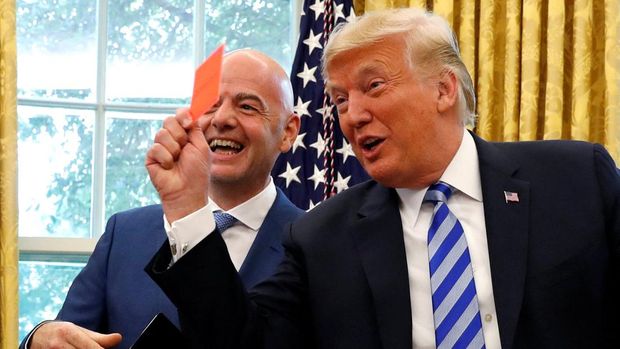 FILE PHOTO: U.S. President Donald Trump holds up a red card as he meets with FIFA President Gianni Infantino in the Oval Office of the White House in Washington, U.S., August 28, 2018. REUTERS/Leah Millis/File Photo