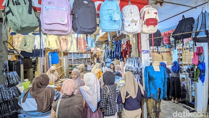 Ibu-ibu terlihat memenuhi toko pakaian untuk membeli seragam sekolah anaknya jelang tahun ajaran baru.