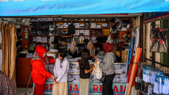 Pekerja melayani calon pembeli seragam sekolah di Pasar Kosambi, Bandung, Jawa Barat, Rabu (8/7/2026). Pemilik toko seragam sekolah menyatakan, jelang tahun ajaran baru 2026/2027 seragam yang dijual dari harga Rp150 ribu hingga Rp250 ribu per set tersebut mengalami peningkatan sebanyak 100 persen penjualan atau dapat terjual 150 pasang per hari dibandingkan hari biasa dan di prediksi akan terus meningkat hingga hari Minggu 12 Juli 2026. ANTARA FOTO/Raisan Al Farisi/wsj.