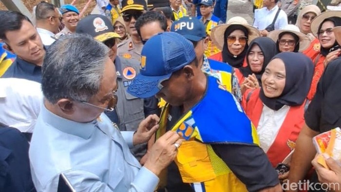 Menteri PU Dody Hanggodo menghadiahi rompi yang dikenakannya ke inisiator perbaikan Jembatan Enang-Enang, Bener Meriah, Syahrial Abadi. (Foto: Agus Setyadi/detikSumut).