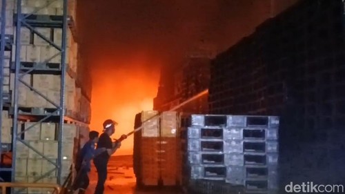 Petugas Damkar memadamkan api saat kebakaran lima gudang Alfamart di Jalan Yos Sudarso, Kecamatan Alak, Kota Kupang, NTT, Selasa (7/7/2026).