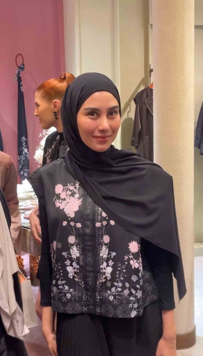 Syahnaz Sadiqah tampil dalam balutan hijab pashmina hitam yang disampirkan anggun ke bahu untuk melengkapi busana berbahan grove twill premium. Gaya hijab simple ini berpadu dengan atasan berkancing depan yang dipercantik detail bordir floral bernuansa merah muda serta aksen tali pita samping yang manis. Foto: Dok. Gresnia/Wolipop.