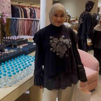Aryani Fitriana tampil dalam balutan hijab clean look serba hitam yang berpadu serasi dengan knit vest berbahan rajut rayon premium. Rompi hitam berkerah tinggi hadir dengan detail bordir floral di bagian depan serta aksen tali pita di sisi samping. Foto: Dok. Gresnia/Wolipop.