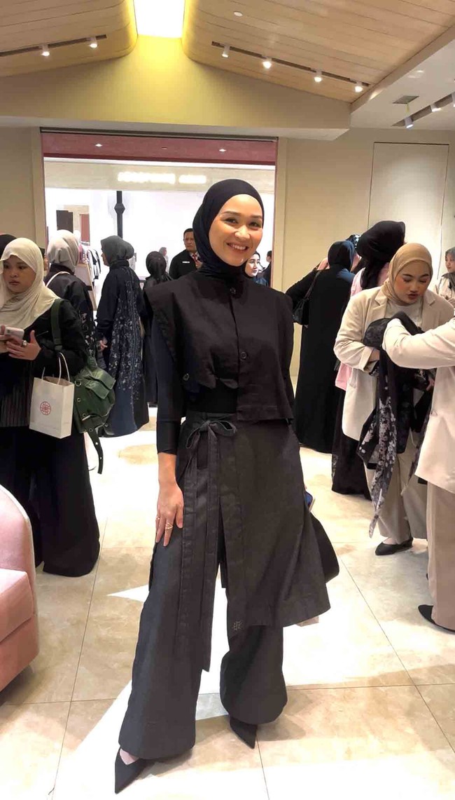 Putri kedua Indro Warkop, Satya Paramita Hada Dwinita atau Hada Kusumonegoro, tampil mencuri perhatian dengan gaya hijab lilit serba hitam bergaya clean look. Penampilan minimalis tersebut berpadu sempurna dengan padanan busana kontemporer berupa rompi hitam pendek, baju manset ketat, serta celana berpotongan longgar dengan aksen lilitan kain abu-abu gelap. Foto: Dok. Gresnia/Wolipop.