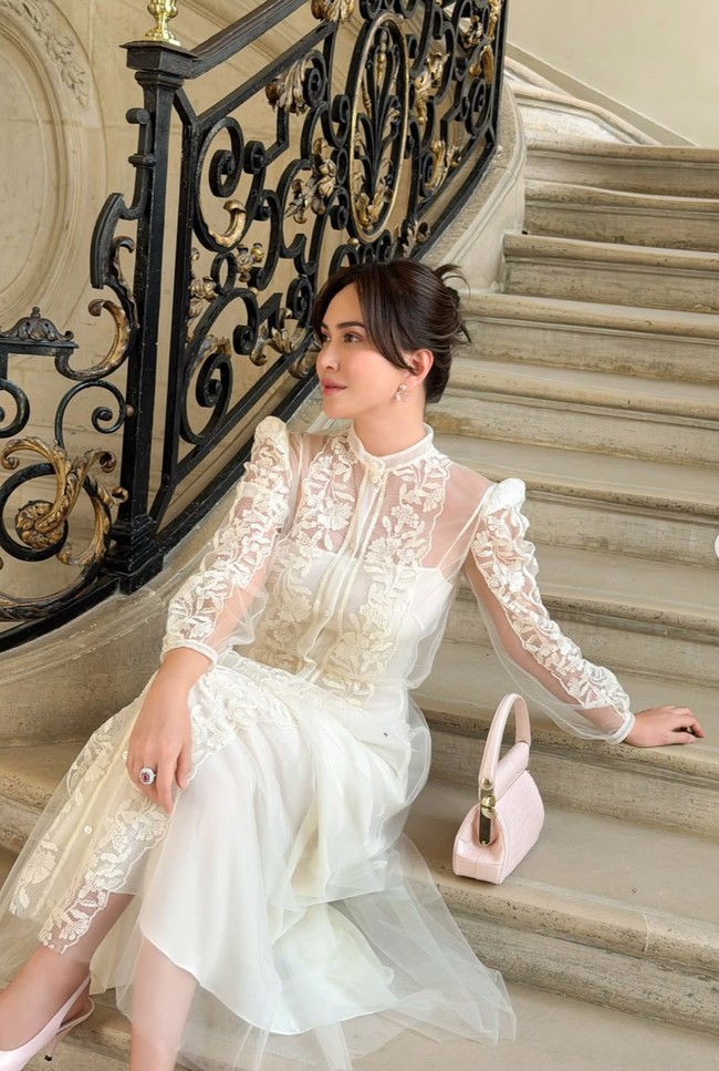 Rambutnya  ditata low bun dengan belahan tengah. Beberapa helai rambut dibiarkan membingkai wajah sehingga tampilan terasa lembut dan effortless. Wajahnya terlihat glowing dengan riasan bernuansa soft glam. Foto: Instagram/@shandyaulia