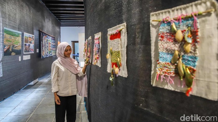 Seorang pengunjung menikmati karya yang dipamerkan dalam pameran bertajuk Suara Dari Muara di Museum Bahari, Jakarta Utara, Rabu (8/7/2026). Pameran ini menampilkan karya fotografi, instalasi, dan kerajinan tangan yang dibuat oleh perempuan Muara Angke.