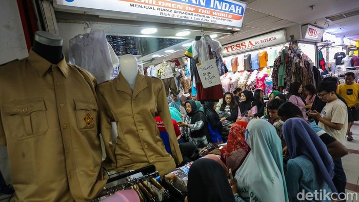 Sejumlah orang tua memilih seragam sekolah di salah satu kios perlengkapan sekolah di Pasar Tanah Abang Blok A, Jakarta, Kamis (9/7/2026).