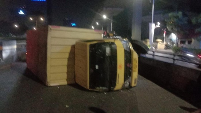 Kecelakaan truk boks kuning terguling di flyover Kuningan, Jakarta Selatan. (X @TMCPoldaMetro)