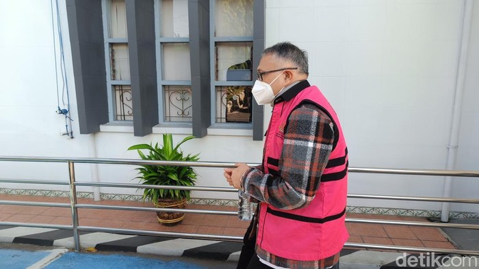 Mantan Kepala Balai Besar Pembibitan Ternak Unggul dan Hijauan Pakan Ternak (BBPTUHPT) Baturraden berinisial SHH menggunakan rompi merah muda dan tangan terborgol saat akan digelandang ke Rutan Banyumas, Kamis (9/7/2026).