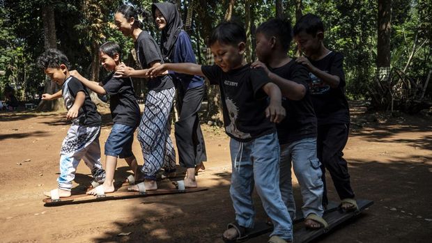 Sejumlah anak bersama pendamping bermain pada kegiatan bertajuk Liburan Sehat Ceria Tanpa Handphone di Sanggar Seni dan Budaya Omah Alas, Desa Wisata Kandri, Gunungpati, Semarang, Jawa Tengah, Kamis (9/7/2026). Sanggar Seni dan Budaya Omah Alas menggelar kegiatan yang diisi dengan permainan tradisional seperti egrang, bakiak, dan gobag sodor, serta kegiatan mewarnai topeng, guna mengurangi paparan gawai pada anak selama masa libur sekolah, sekaligus mengenalkan budaya Nusantara, mengembangkan kreativitas, dan memperkuat interaksi sosial. ANTARA FOTO/Aprillio Akbar/kye