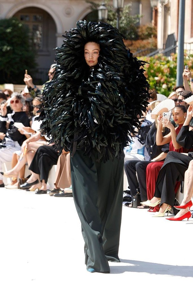 Penampilan Gigi ini langsung menjadi sorotan karena dipenuhi bulu, hingga hanya wajahnya yang terlihat. Siluet dramatis tersebut membuatnya hampir tak dikenali saat melangkah di atas runway. Foto: Getty Images/Estrop