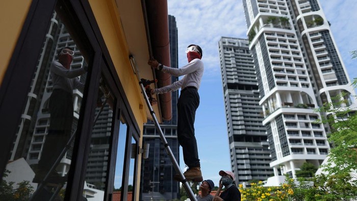 Bee rescuer Clarence Chua inspects the roof of an apartment for bee nests, in Singapore, June 8, 2026. REUTERS/Edgar Su