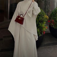 Rima tampil mengenakan atasan asimetris dan rok bergaris senada. Dia melengkapi penampilannya dengan tas Hermes Kelly yang harganya mencapai US$ 20.000 atau sekitar Rp 360 juta. Foto: Dok. Instagram VogueMagazine, Rima Edbouche
