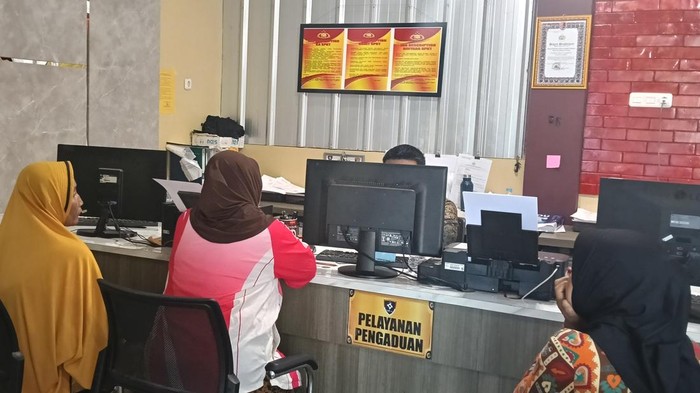 Korban Misnawati ditemani saudaranya saat melapor ke Polrestabes Palembang